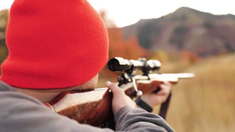 Young-Man-Hold-Rifle-and-Looks-Through-Scope-to-Aim-with-Mountains-in-the-Background-1080p-60fps