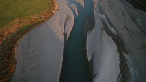 Aerial-pan-up-over-New-Zealand-alpine-river-to-snow-capped-mountains
