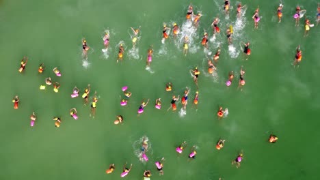 swimmers-start-of-race-swimming-at-sea-green-drone-shot-forward