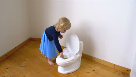 A-child-scrubbing-a-potty-toilet-bowl-with-a-brush