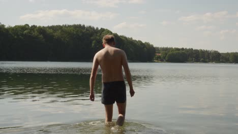Hombre-Sin-Camisa-Nada-En-El-Lago-De-Jezioro-Glebokie-En-Polonia