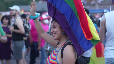 A-static-shot-of-a-beautiful-smiling-lady-waving-rainbow-flag-in-LGBT-Pride-Parade,-Monterrey