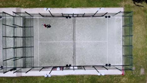 One-young-athlete-training-alone-for-a-paddle-game,-bird's-eye-view-aerial-drone-shot