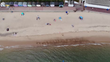 Drone-footage-of-People-sun-bathing-on-the-beach-in-Clacton-on-Sea,-Essex,-UK