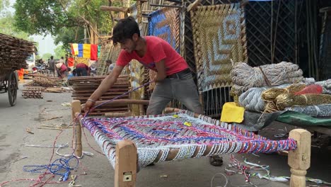 A-worker-ties-rope-to-prepare-a-sustainable-affordable-wooden-cot