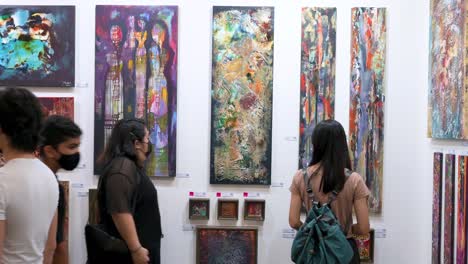 Los-Compradores-De-Arte-Miran-Las-Pinturas-A-La-Venta-Durante-Una-Feria-De-Arte-Contemporáneo-Abierta-Al-Público