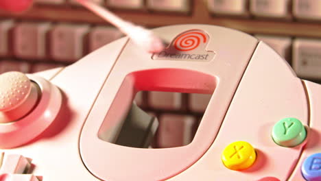Reinigung-Des-Sega-Dreamcast-Controllers-Mit-Tastatur-Im-Hintergrund,-Nach-Links-Schieben