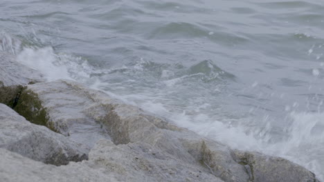 Gentle-lake-waves-lapping-against-the-rocky-shoreline