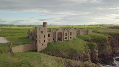 Aerial-view-of-a-Slains-Castle-ruin-at-sunrise,-Aberdeenshire,-Scotland