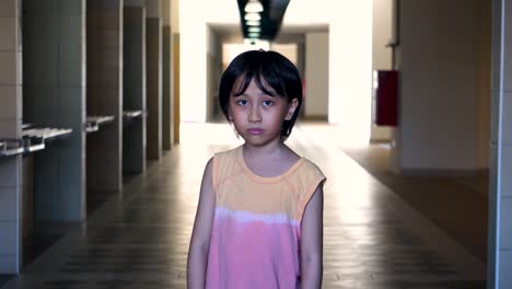 Porträt-Eines-Jungen-Südostasiatischen-Jungen,-Der-Allein-Angst-Hat,-In-Einem-Verlassenen-Einkaufszentrum-Mit-Licht-Und-Schatten-Im-Hintergrund-In-Die-Kamera-Zu-Schauen