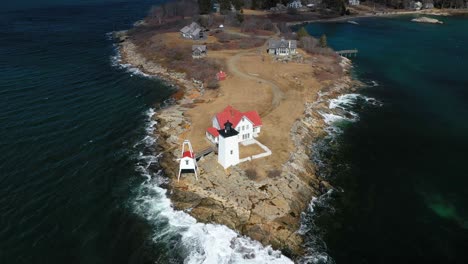 Flying-over-Hendricks-Head-Lighthouse-on-a-sunny-day-with-cloud-shadows-passing-AERIAL