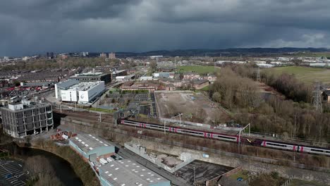 Luftaufnahmen-Von-Zügen,-Die-Sich-Dem-Bahnhof-Stoke-On-Trent-In-Den-Midlands-Am-Kanal,-Am-Wasser-Und-An-Der-Autobahn-A50-Nähern,-Dem-Halbwegspunkt-Für-Pendler,-Die-Nach-Norden-Und-Süden-Durch-Großbritannien-Reisen