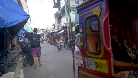 People-walk-along-a-crowded-narrow-street-in-Tawi-Tawi,-a-small-Philippine-island,-carrying-groceries-and-goods
