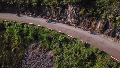 Drone-view-showing-a-group-of-motorcyclists-resting-on-the-side-of-the-road,-along-the-Ma-Pi-Leng-Pass-in-the-late-afternoon