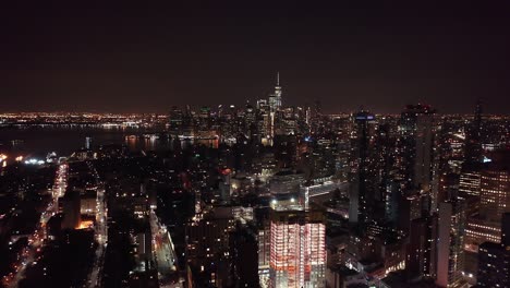 Drone-footage-of-the-Manhattan-city-skyline-at-night,-taken-from-Brooklyn,-New-York