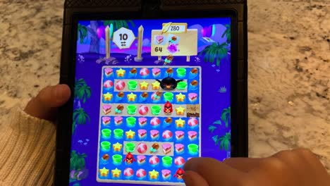 Little-fingers-playing-a-popular-puzzle-game-on-the-iPad-called-"Angry-Birds-Match"