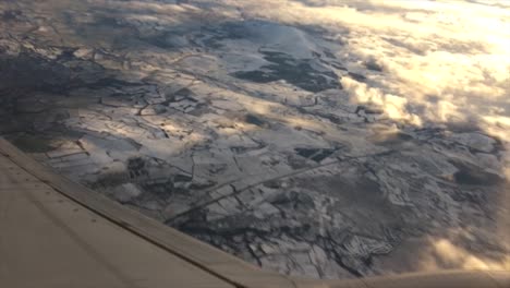 Jet-banks-hard-left-after-take-off-and-looking-out-jet-airplane-window-as-it-levels-out-looking-at-freshly-snow-covered-ground-in-the-north