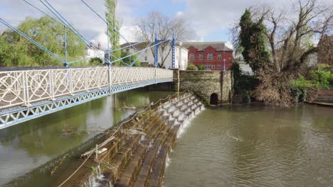 Kunstvolle-Eisenbrücke,-Die-An-Einem-Sonnigen-Tag-Eine-Fließende-Abnutzung-In-Einem-Park-In-Leamington-Spa-überquert
