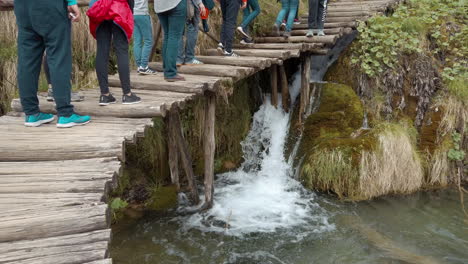 Tourists-walk-along-the-wooden-walkways-over-the-top-of-waterfalls-and-lakes-and-Plitvice