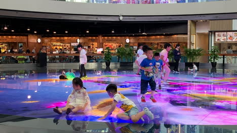 A-few-kids-playing-on-the-floor-with-colourful-lights-that-strikes-on-the-floor