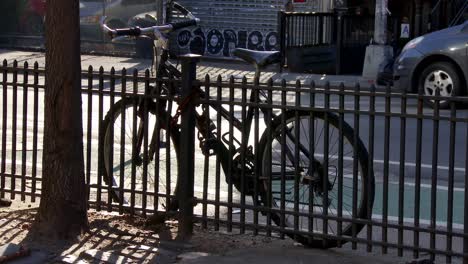 Bicycle-parked-next-to-fence--on-the-street