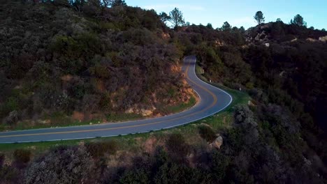 Tight-Curve-of-Mountain-Road-beside-Steep-Cliff-at-Dawn,-Drone-Orbit