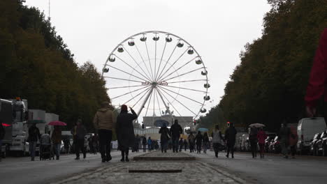 People-walking-towards-Tiergarten-park-in-Berlin-with-Ferris-wheel-in-background