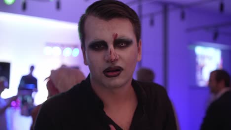 Male-with-face-paint-looking-up-during-carnival-party,-slowmo