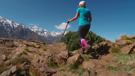 Tourist-girl-walks-to-mountain-ridge-in-High-Atlas-to-see-Toubkal-massif,-slow-motion
