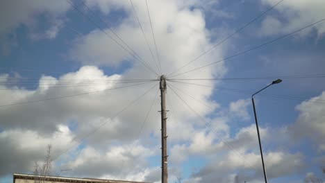 Electric-and-telephone-wires-on-the-lamppost-with-clouds-in-the-sky-on-the-background
