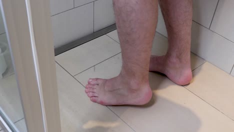 Blutstropfen-Fallen-Auf-Die-Füße-Und-Beine-Eines-Mannes,-Der-Barfuß-In-Seinem-Badezimmer-Steht