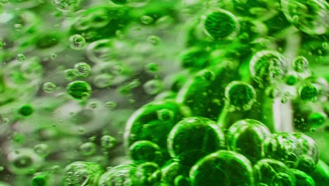 macro-shot-of-green-bubbles-getting-mixed-in-water,-moving-around