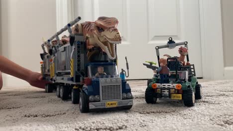 Kind-Spielt-Mit-Lego-Spielzeugen-Aus-Der-Jurassic-Welt,-Die-Dinosaurier-Transportieren