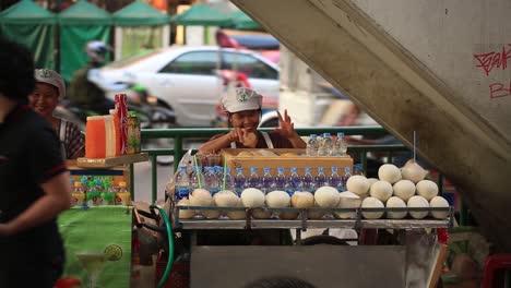 Bangkok,-Tailandia---Vendedores-Ambulantes-Que-Venden-Comida-Y-Bebidas-En-El-área-De-Pratunam-Con-Vehículos-De-Transporte-Que-Pasan-En-El-Fondo---Toma-De-Primer-Plano
