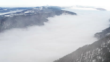 Drone-Volando-A-Través-De-Nubes-Delgadas-Sobre-Un-Valle-Cubierto-De-Nubes
