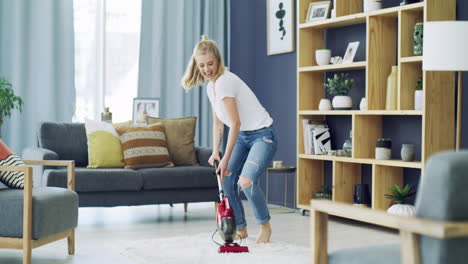 a-happy-young-woman-vacuuming-the-living-room