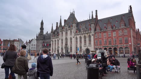 Wide-shot-of-Bruges'-main-square,-the-Market-Square,-with-the-Basilica-of-the-Holy-Blood-in-the-background