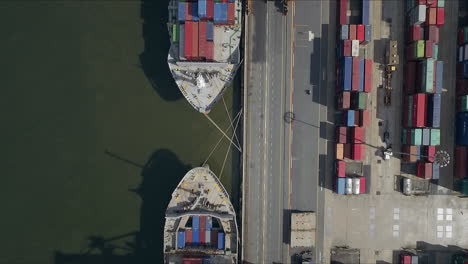 Logistic-concept-aerial-shot-of-commercial-maritime-transport-dockyard-with-cargo-ships-waiting-to-be-upload---offload-cargo-containers