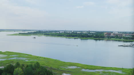 Wide-View-of-Lone-Boat-Traveling-Down-Ashley-River-in-Charleston,-SC