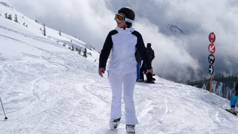 Winter-landscape-with-woman-in-white-ski-suit-walking-towards-camera