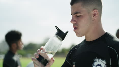 Un-Joven-Jugador-De-Rugby-Bebiendo-Agua-Mientras-Toma