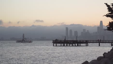 Das-Boot-Der-US-Küstenwache-Fährt-An-Einem-Angelpier-Mit-San-Francisco-Im-Hintergrund-Vorbei