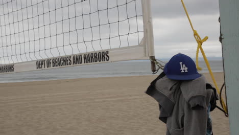 Sombrero-De-Los-Angeles-Dodgers-En-La-Cancha-De-Voleibol-De-Playa,-Sombrío-Día-De-Playa-En-La