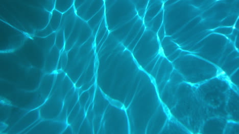 Wellenmuster-Spielen-über-Die-Oberfläche-Des-Schwimmbadbodens