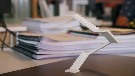 Foam-Staircase-Model-Sitting-Freely-on-Architects-Desk-in-Office,-Camera-Pan