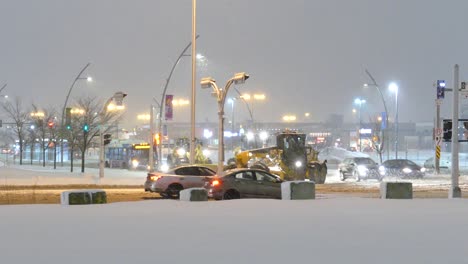 Parade-of-snow-grader-trucks-clearing-snow-while-turning-busy-street-corner
