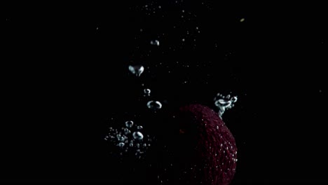 Avocado-Fällt-Ins-Wasser-Super-Slowmotion,-Schwarzer-Hintergrund,-Viele-Luftblasen,-4k240fps