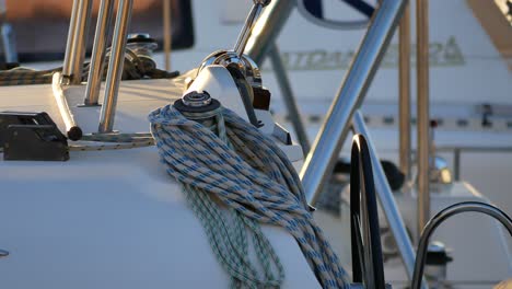 A-shot-of-a-ship-helm-with-rolled-ropes-near-it,-swaying-slowly-with-the-waves-in-a-sport-pier