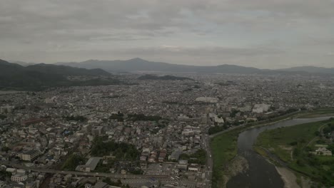 Luftdrohnenaufnahme-Von-Kyoto-Bei-Sonnenuntergang-In-Der-Nähe-Eines-Flusses,-Japan,-Asien