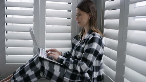 a-young-woman-using-a-laptop-in-the-morning